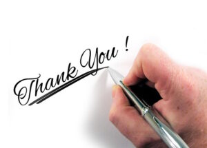 Human hand writing Thank You on a card